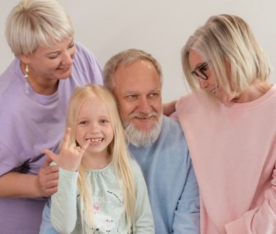 A joyful multigenerational family poses and smiles together indoors, showcasing love and togetherness.