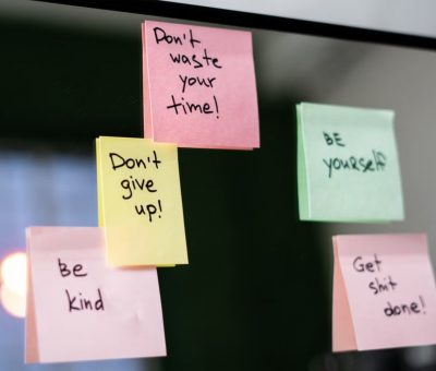 Colorful sticky notes with motivational messages on a mirror reflecting positivity.